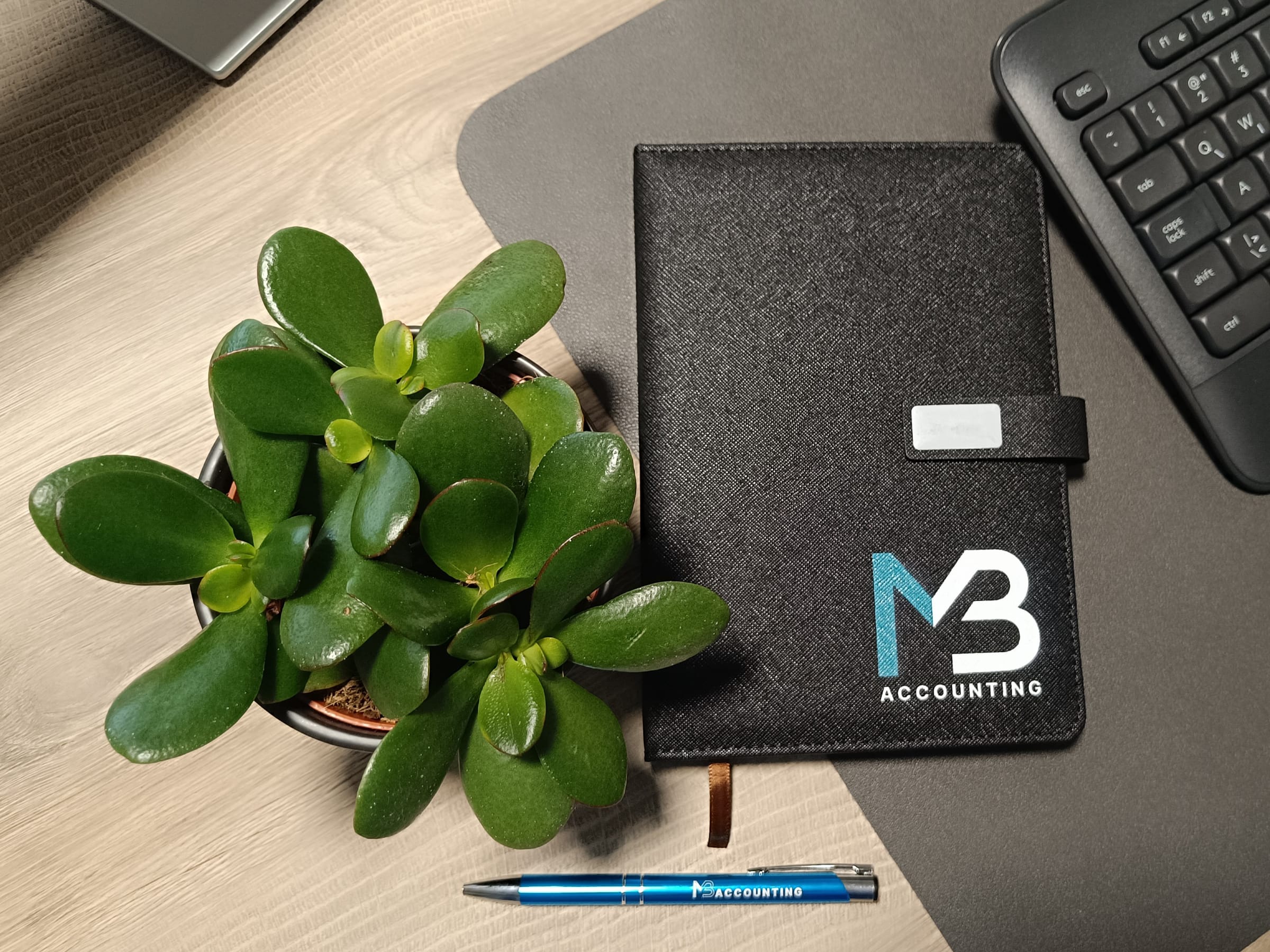 Radni stol MB Accounting & Consulting s brendiranom bilježnicom i olovkom